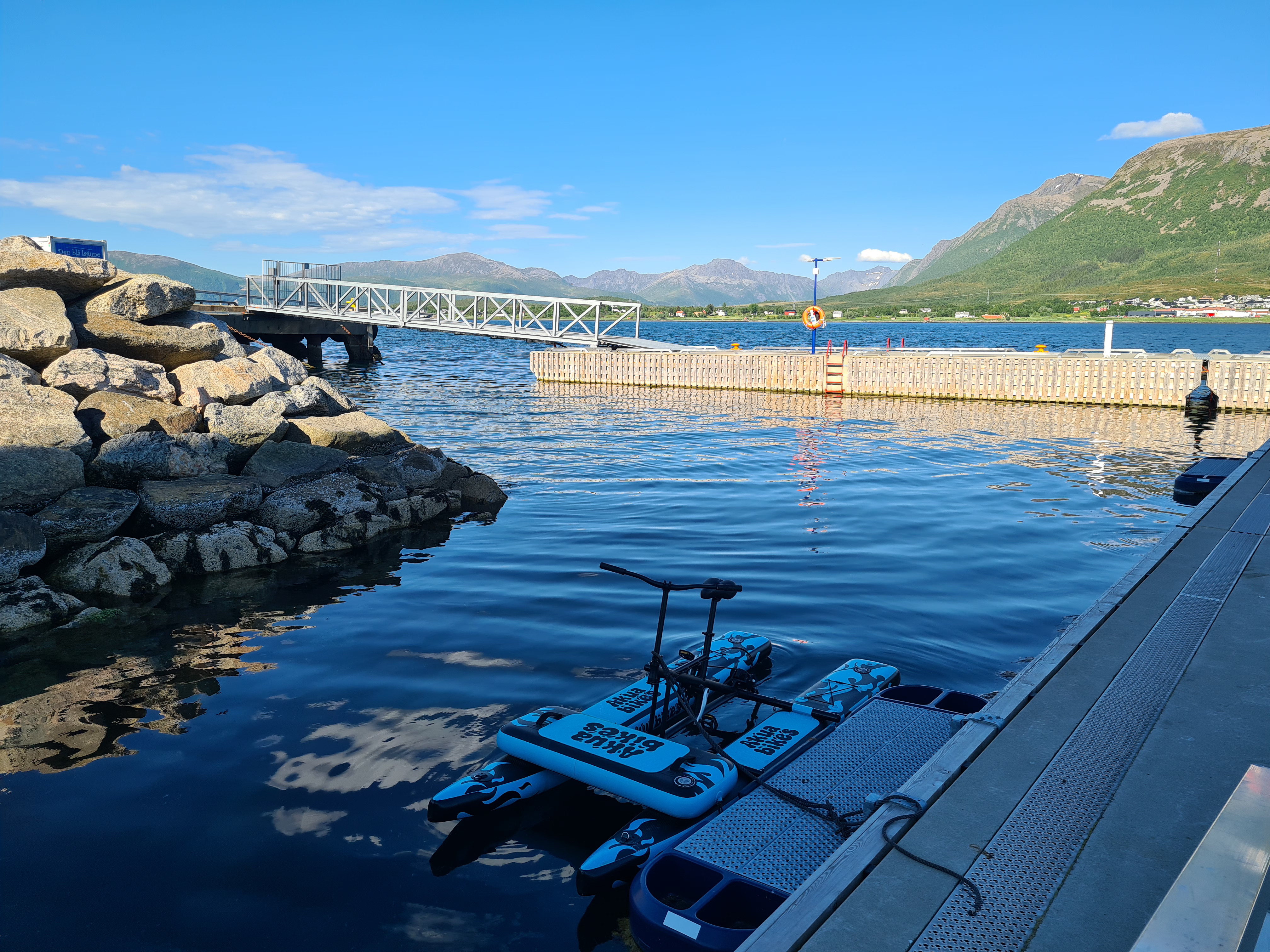 Vannsykkel ved brygge med fjell og vann